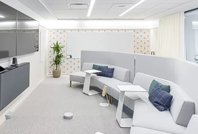 Office room with sofa seating and two TVs