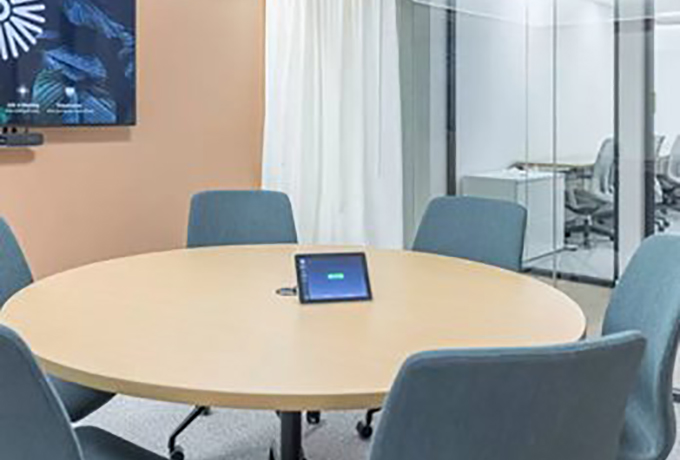 A table with chairs around it and on the table is a tablet