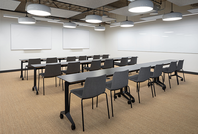 Room full of desks and chairs facing towards two whiteboards